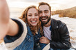 © Drobot Dean - Image of caucasian couple taking selfie photo while walking by seaside