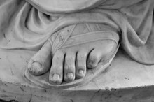 Foot. Fragment Of An Antique Marble Statue. Cracked Ground In The Background. Plaster Limb, Foot Male With Fingers, Body Part. Foots Of Ancient Granite Statue Of Man Isolaated On White Background