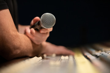 Sticker - Close-up of classic microphone in hand of a music producer