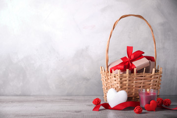 Greeting card Valentine's day with hearts ,goblet and gifts in basket on wooden background. With space for your text greetings