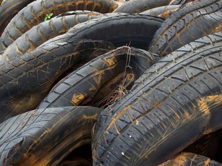 Close up of a pile of old tires squeezed together at a dump site