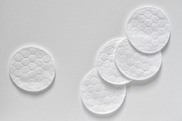 Wall Mural - Cotton sponges or cotton cosmetic pads on the light background. Closeup, top view