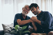 © chokniti - Hipster son with his senior father at home.