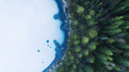Wall Mural - Aerial view of a beautiful frozen lake and forests in winter. Photo of the northern nature of Finland with a drone.