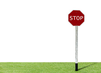 Stop sign on green grass with white background.