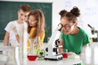 © New Africa - Schoolgirl looking through microscope and her classmates at chemistry class