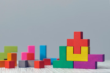 wooden block puzzle. wood cube stacking. Concept of complex and smart logical thinking. Slightly defocused and close up shot. on a red background