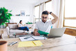 © BullRun - Confused bearded man in round glasses reread information on green paper at home