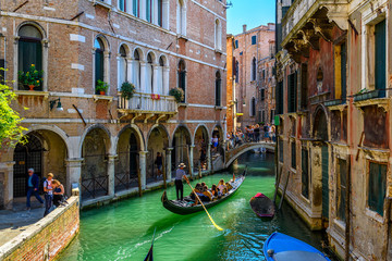 narrow canal with gondola and bridge in venice, italy. architecture and landmark of venice. cozy cit