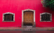 Puerta en pared roja, con dos ventanas
