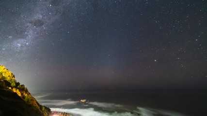 Wall Mural - The Milky Way galactic core crossing above the sky on a natural sea environment. Amazing view over our universe on a starry night above the Pacific Ocean with the sea crashing the coastine and cliffs