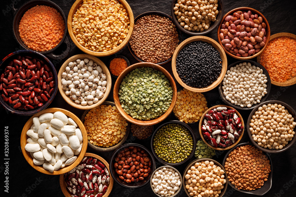 Legumes, a set consisting of different types of beans, lentils and peas on a black background, top view. The concept of healthy and nutritious food - obrazy, fototapety, plakaty 