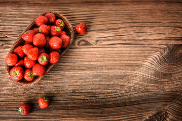 Wall Mural - Whole strawberries in wooden bowl. Fresh nice strawberries on wooden table. Juice strawberry fine collected.