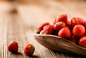 Wall Mural - Whole strawberries in wooden bowl. Fresh nice strawberries on wooden table. Juice strawberry fine collected.