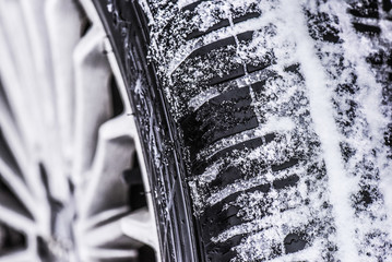 Wall Mural - Winter tire. Car on snowy road. Tires on snow highway close up.