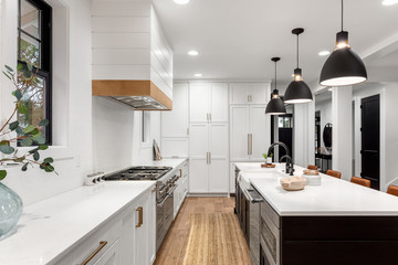 Beautiful white kitchen with dark accents in new modern farmhouse style luxury home