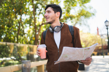 Traveler man holding a map and looking for directions.