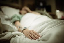Sick Woman Lying In Hospital Bed 