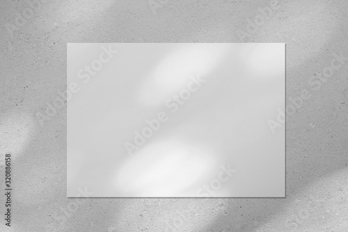 Fotomural Empty white horizontal rectangle poster or business card mockup with diagonal dappled light spots on gray concrete wall