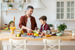 © deniskomarov - Father and son cooking fresh vegetables on kitchen