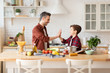 © deniskomarov - Happy father and son family on kitchen portrait