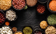 Legumes, a set consisting of different types of beans, lentils and peas on a black background, top view, copy space. The concept of healthy and nutritious food