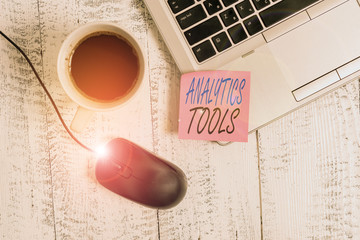Writing note showing Analytics Tools. Business concept for pieces of web application analysis software used to monitor Trendy metallic laptop blank sticky note coffee cup mouse lying vintage