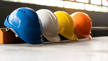 Safety Construction Worker Hats Blue, White, Yellow, Orange. Teamwork Of Construction Team Must Have Quality. Whether It Engineer, Construction Workers. Have A Helmet To Wear At Work. Safety At Work.