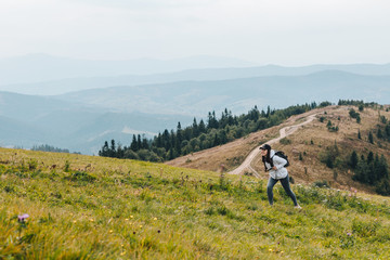 Wall Mural - woman with backpack hiking in mountains