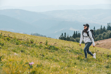 Wall Mural - woman with backpack hiking in mountains