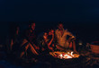 © qunica.com - Campfire people roasting sausages and playing guitar