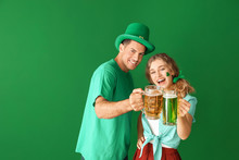 Young Couple With Beer On Color Background. St. Patrick's Day Celebration