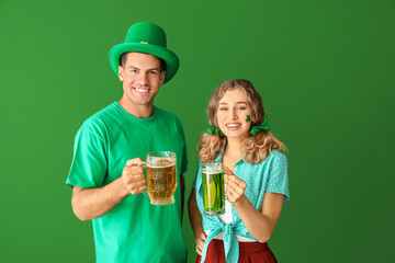 Poster - Young couple with beer on color background. St. Patrick's Day celebration