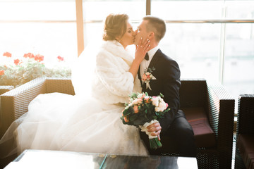 Beautiful bride and groom embracing and kissing on their wedding day