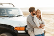 © Drobot Dean - Loving couple outdoors at beach near car hugging.