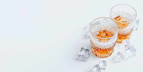 two glasses of whiskey with ice on a white background with place for text