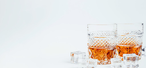 two glasses of whiskey with ice on a white background with place for text