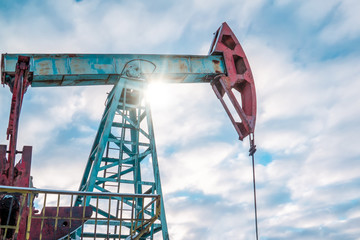 Oil pump jack rocking with pipeline in the background. Rocking machines for power generation. Extraction of oil. A pumpjack is the overground drive for a reciprocating piston pump in an oil well.