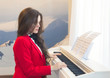Young beautiful woman playing the piano at home