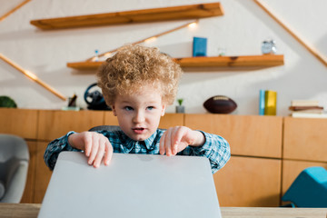 Wall Mural - adorable and smart child touching laptop while studying at home