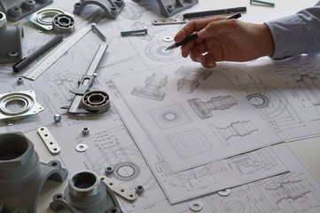 Fototapete - Engineer technician designing drawings mechanical parts engineering Engine.manufacturing factory Industry Industrial work project blueprints measuring bearings caliper tools
