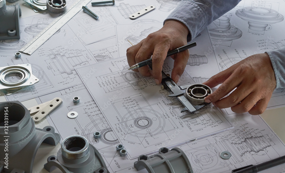 Engineer technician designing drawings mechanical parts engineering Engine.manufacturing factory Industry Industrial work project blueprints measuring bearings caliper tools - obrazy, fototapety, plakaty 