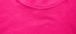 Pink shirt fabric texture with collar neck detail. Colorful vibrant pink color background, casual clothes material, blank plain t-shirt surface 