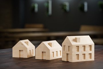 Wall Mural - which size of house can you afford? concept shot: three differently sized wooden models of houses on