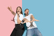© master1305 - Scene. Dancing, singing, having fun. Young and happy man and woman in casual clothes on pink, blue bicolored background. Concept of human emotions, facial expession, relations, ad. Beautiful couple.