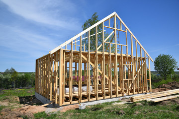 Wood frame residential building under construction.Building construction, wood framing structure at new property development site.new home currently under construction against blue sky.mortgage, loan.