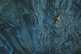 Powerful sportive rock climber climbing 
