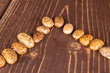 Group of thirteen whole mottled brown bean pinto on brown wood