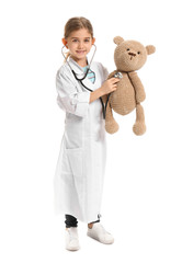 Canvas Print - Cute little doctor with toy on white background