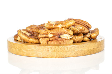 Wall Mural - Lot of whole tasty brown pecan half on round bamboo coaster isolated on white background